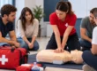 Instructora realizando una demostración de reanimación cardiopulmonar (RCP) con un maniquí durante un curso de primeros auxilios en Gijón.